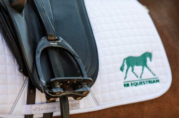 Flex-on stirrups on a saddle pad embroidered with the RB Equestrian logo